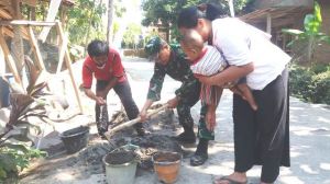 Semangat Seorang Ibu Dengan Mengendong Anaknya Ikut Membantu Satgas TMMD