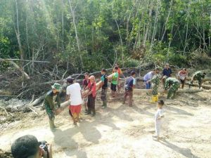 Satgas dan Warga Bahu Membahu Membawa Papan dan Kayu untuk Material Jembatan
