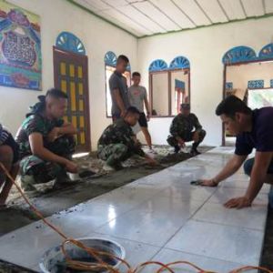 Warga dan Satgas TMMD Gotong Royong Pasang Keramik Musollah Baitul Mukmin 
