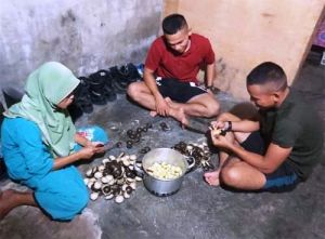 Bersama Orang Tua Asuh, Satgas TMMD Prada Hasibuan Bantu Kupas Jengkol untuk Makan Malam