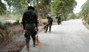 Anggota Satgas Yang Terus Bersihkan Sampah di Jalan TMMD