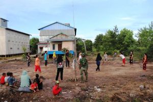 Semangat Emak - emak Bermain Voli Saat Anggota Satgas TMMD Menjadi Wasit
