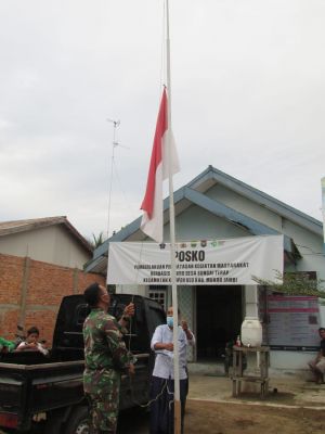 Satgas TMMD Bersama Warga Turunkan Bendera Merah Putih di Balai Desa