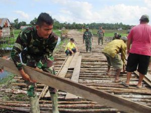 Warga Bersama Satgas TMMD Pasang Papan Diatas Galar Agar Lebih Kokoh